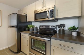 A kitchen with stainless steel appliances and a microwave 